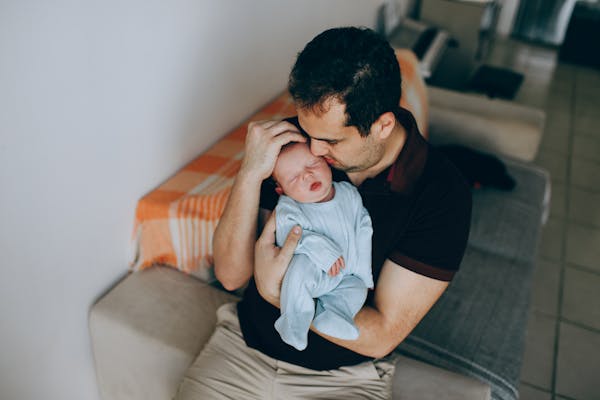 Parent gently holding a peaceful sleeping newborn